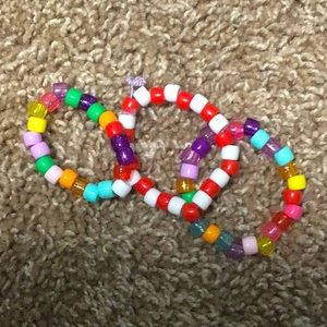 A candy cane bracelet and two rainbow bracelets